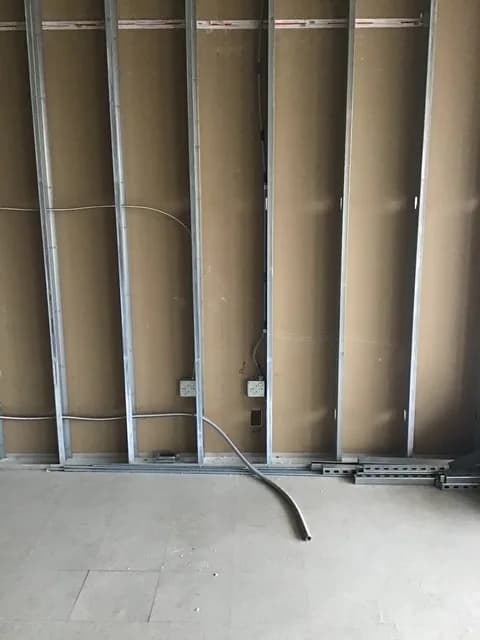 Steel-stud framing with electrical boxes set and rough-in cabling pulled before drywall